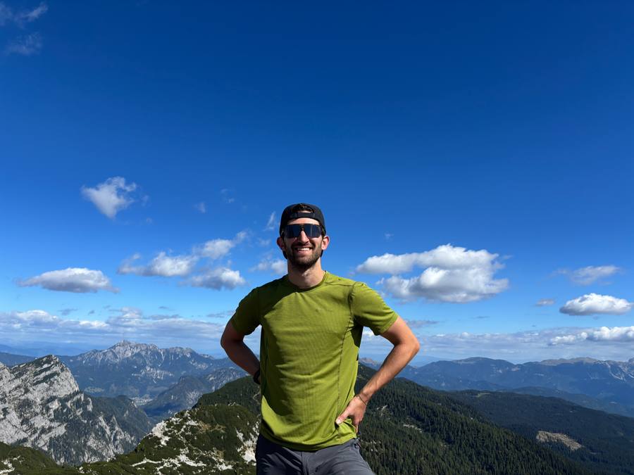 Jamie smiling on a mountain summit in Slovenia